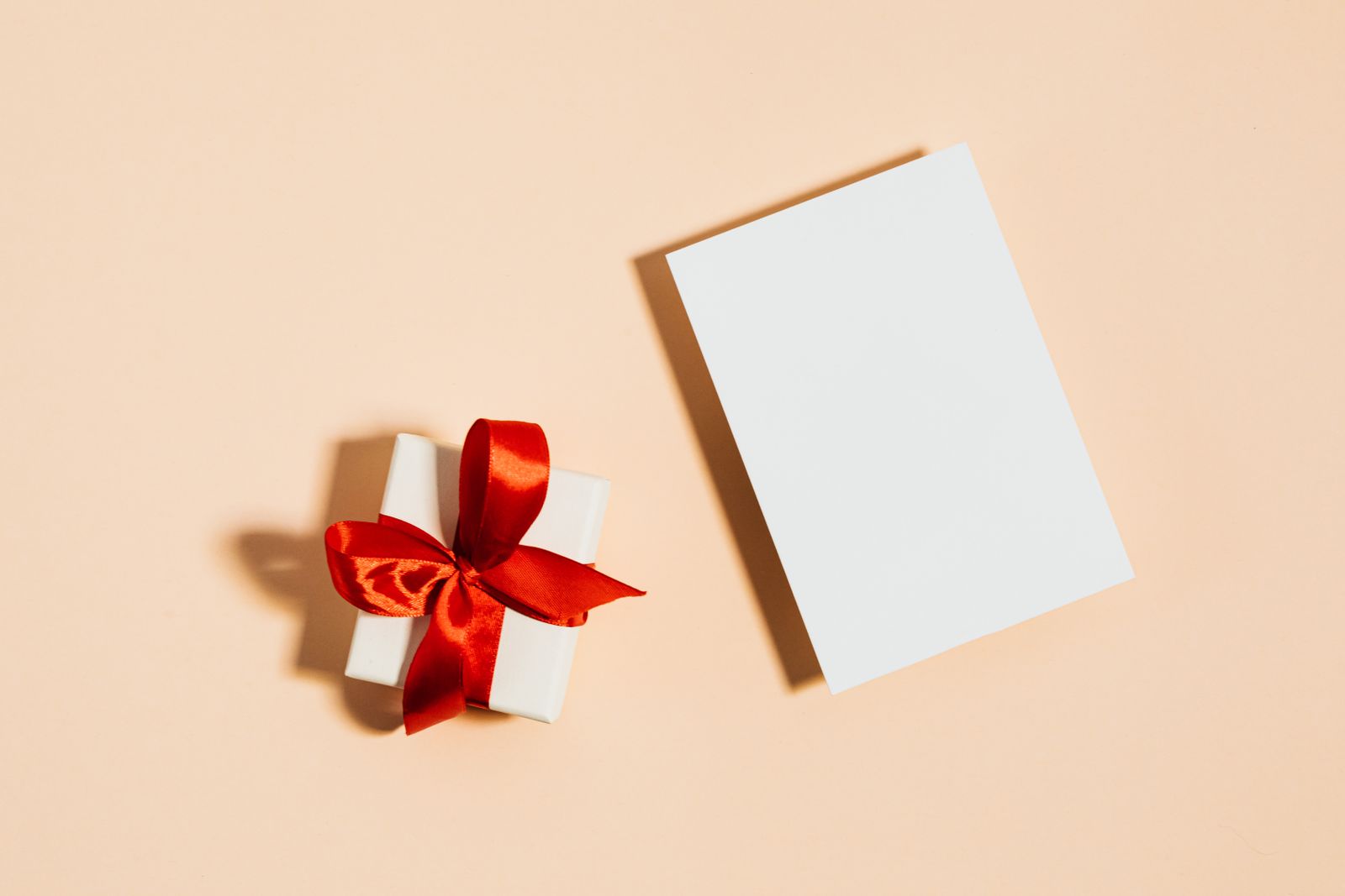 White paper beside a small box with red ribbon